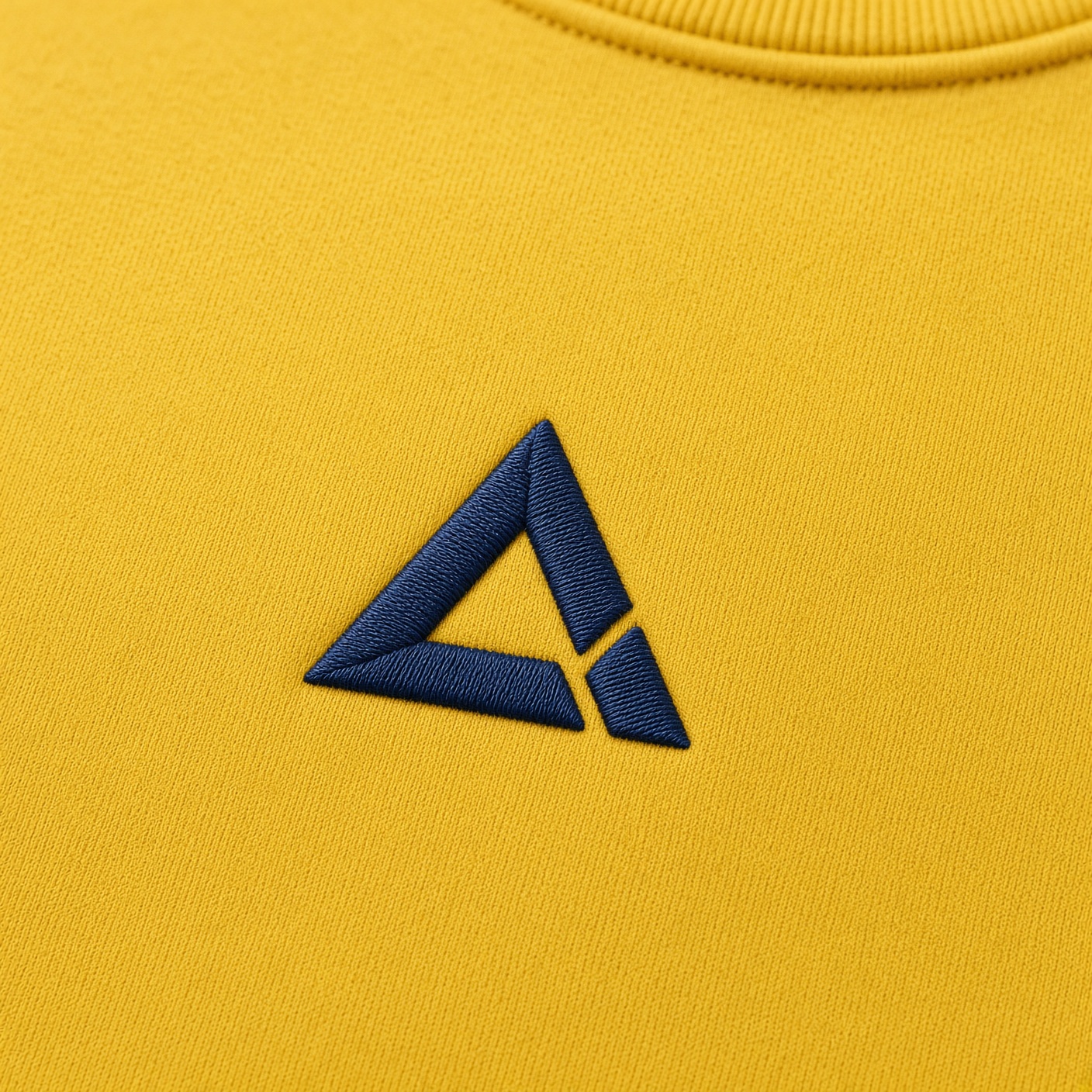 Mustard crewneck with a navy embroidered chest mark